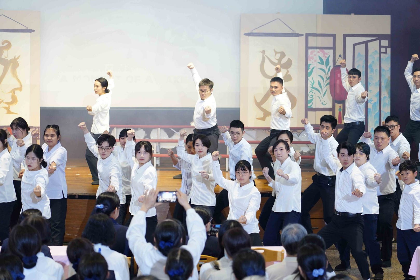 A group of Kung Fu apprentices in white clothes perform a martial arts dance together